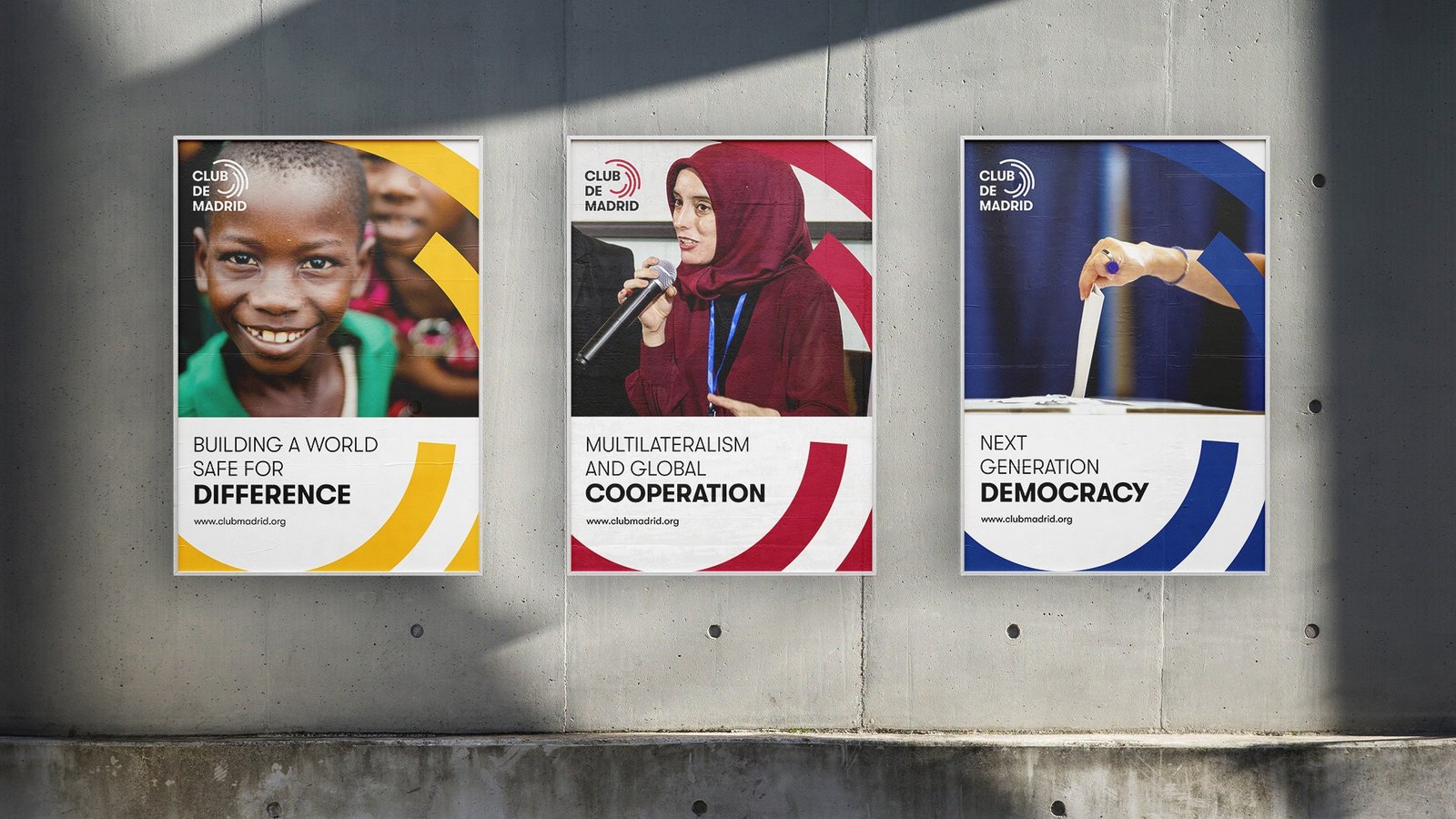 Club de Madrid campaign posters displayed on a concrete wall.